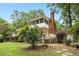 This lush backyard features a brick home with covered porch and a screened balcony at 9509 Greenfield Dr, Raleigh, NC 27615