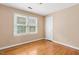 Bright bedroom with hardwood floors, neutral wall color, and window offering natural light at 9509 Greenfield Dr, Raleigh, NC 27615