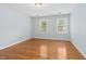 Serene bedroom featuring hardwood floors and two windows with wood blinds for natural light at 9509 Greenfield Dr, Raleigh, NC 27615