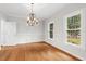 Elegant dining room with hardwood floors, a chandelier, and large windows at 9509 Greenfield Dr, Raleigh, NC 27615