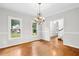 Bright dining room featuring hardwood floors, large windows, and a view of the staircase at 9509 Greenfield Dr, Raleigh, NC 27615