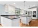Bright kitchen featuring white cabinetry, a center island with cooktop, and modern appliances at 9509 Greenfield Dr, Raleigh, NC 27615