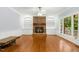 Cozy living room features a brick fireplace, built-in shelving, and hardwood floors at 9509 Greenfield Dr, Raleigh, NC 27615