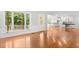 Bright living room featuring hardwood floors, white trim, and large windows with views of the wooded outdoors at 9509 Greenfield Dr, Raleigh, NC 27615