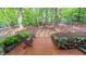 Outdoor wooden deck showcasing stone planters, and patio chairs, creating a cozy spot surrounded by lush landscaping and privacy at 1 Davie Ln, Chapel Hill, NC 27514