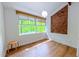 Bright bedroom with wood floors, a large window, and exposed brick feature wall at 1 Davie Ln, Chapel Hill, NC 27514