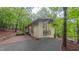 Stylish exterior with walls of glass, complementing the lush forest surroundings, inviting natural light and scenic views at 1 Davie Ln, Chapel Hill, NC 27514