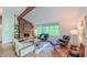 Inviting living room featuring sleek modern furniture, hardwood floors, a brick fireplace, and natural light from large windows at 1 Davie Ln, Chapel Hill, NC 27514