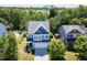 Scenic aerial shot of a two-story home in a lush neighborhood, surrounded by mature trees and landscaping at 1004 Bridlemine Dr, Fuquay Varina, NC 27526