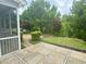 Serene backyard featuring a stone patio, lush landscaping, and mature trees at 1004 Bridlemine Dr, Fuquay Varina, NC 27526