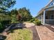 Backyard features patio, fire pit, and screened porch amid lush lawn and mature trees at 1004 Bridlemine Dr, Fuquay Varina, NC 27526