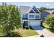 Inviting two-story home with a well-maintained lawn, complemented by lush trees and a two-car garage at 1004 Bridlemine Dr, Fuquay Varina, NC 27526