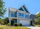Attractive two-story home featuring a blue front door and a convenient two-car garage at 1004 Bridlemine Dr, Fuquay Varina, NC 27526