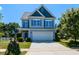 Charming two-story home with gray siding, blue shutters, and a well-manicured front yard at 1004 Bridlemine Dr, Fuquay Varina, NC 27526