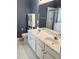 Bright bathroom featuring a dual sink vanity, toilet, cabinet and glass enclosed shower at 1017 Red Hat Ln, Durham, NC 27713