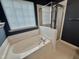 Bright bathroom featuring a soaking tub, glass shower and window blinds at 1017 Red Hat Ln, Durham, NC 27713