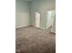 Spacious bedroom with neutral walls, plush carpet, and multiple doorways at 1017 Red Hat Ln, Durham, NC 27713
