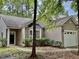 Exterior of a home with attached garage, mature trees and landscaping at 1017 Red Hat Ln, Durham, NC 27713