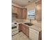 Cozy kitchen featuring stainless steel sink, white appliances and wooden cabinets at 1017 Red Hat Ln, Durham, NC 27713