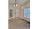 Bright, carpeted living room with a ceiling fan, entry door and large windows at 1017 Red Hat Ln, Durham, NC 27713