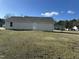 Back exterior of home featuring a spacious yard with potential for outdoor activities at 103 Hampshire Pl, Kenly, NC 27542