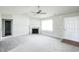 Bright living room featuring a fireplace, large windows, and a ceiling fan for added comfort at 103 Hampshire Pl, Kenly, NC 27542