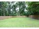 Spacious backyard featuring a well-maintained lawn and a tall wooden privacy fence surrounded by mature trees at 106 E Club Blvd, Durham, NC 27704