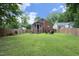 Expansive backyard featuring lush green grass, mature trees, and a brick patio area at 106 E Club Blvd, Durham, NC 27704