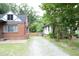 Gravel driveway between two brick homes and a wood fence for privacy at 106 E Club Blvd, Durham, NC 27704