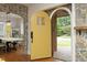 Bright foyer with a unique yellow door leading into a dining area with hardwood floors at 106 E Club Blvd, Durham, NC 27704