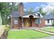 Charming brick home with a striking yellow front door and covered entryway with stone detailing at 106 E Club Blvd, Durham, NC 27704