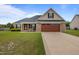 Charming brick home featuring an attached two-car garage and well-manicured front lawn at 106 Lockwood Dr, Cameron, NC 28326