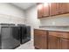 Laundry room with modern washer and dryer units, storage cabinets, and counter space at 106 Lockwood Dr, Cameron, NC 28326