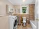 Bathroom with tub, shower, and washing machine plus vanity and natural light at 1085 Bynum Rd, Pittsboro, NC 27312