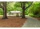 Quaint home with metal roof and a driveway framed by mature trees at 1085 Bynum Rd, Pittsboro, NC 27312