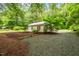 Charming home with metal roof situated on a lot with mature trees and gravel driveway at 1085 Bynum Rd, Pittsboro, NC 27312