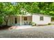 Charming home exterior with covered porch, gravel driveway, and lush landscaping at 1085 Bynum Rd, Pittsboro, NC 27312