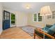 Bright living room with wood floors, rug, large windows and stylish blue sofa at 1085 Bynum Rd, Pittsboro, NC 27312