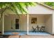 Inviting front porch with a small table, chairs, and covered entryway at 1085 Bynum Rd, Pittsboro, NC 27312