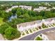 Aerial view of townhouses surrounded by lush greenery and a tranquil pond with a fountain at 109 Ruby Walk Dr, Morrisville, NC 27560