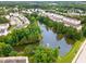 An aerial view showcasing a community with a pond, fountain, mature trees, and townhomes at 109 Ruby Walk Dr, Morrisville, NC 27560