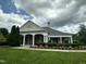 Charming clubhouse featuring a covered entrance, brick facade, and beautifully landscaped grounds at 109 Ruby Walk Dr, Morrisville, NC 27560