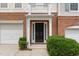 Townhouse entrance featuring a black door, sidelights, brick facade, and landscaped shrubbery at 109 Ruby Walk Dr, Morrisville, NC 27560