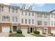 Townhouse featuring vinyl siding, a brick facade, an attached garage, and a manicured lawn at 109 Ruby Walk Dr, Morrisville, NC 27560