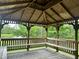 Interior view of a rustic gazebo with benches, offering tranquil views of the surrounding landscape at 109 Ruby Walk Dr, Morrisville, NC 27560