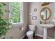 Charming bathroom with pedestal sink, gold hardware, and a window view of lush greenery at 116 Hamilton Hedge Pl, Cary, NC 27519