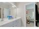 Bathroom vanity featuring double sinks, cabinet storage, and a view into the bedroom at 116 Hamilton Hedge Pl, Cary, NC 27519