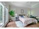 Bright bedroom with wood floors, large windows and door, tray ceiling and floral comforter at 116 Hamilton Hedge Pl, Cary, NC 27519