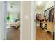 Bedroom with wood floors and closet with hanging clothes and shelving at 116 Hamilton Hedge Pl, Cary, NC 27519