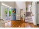 Bright foyer with hardwood floors, staircase, open front door with wreath, and a glimpse of the front porch at 116 Hamilton Hedge Pl, Cary, NC 27519